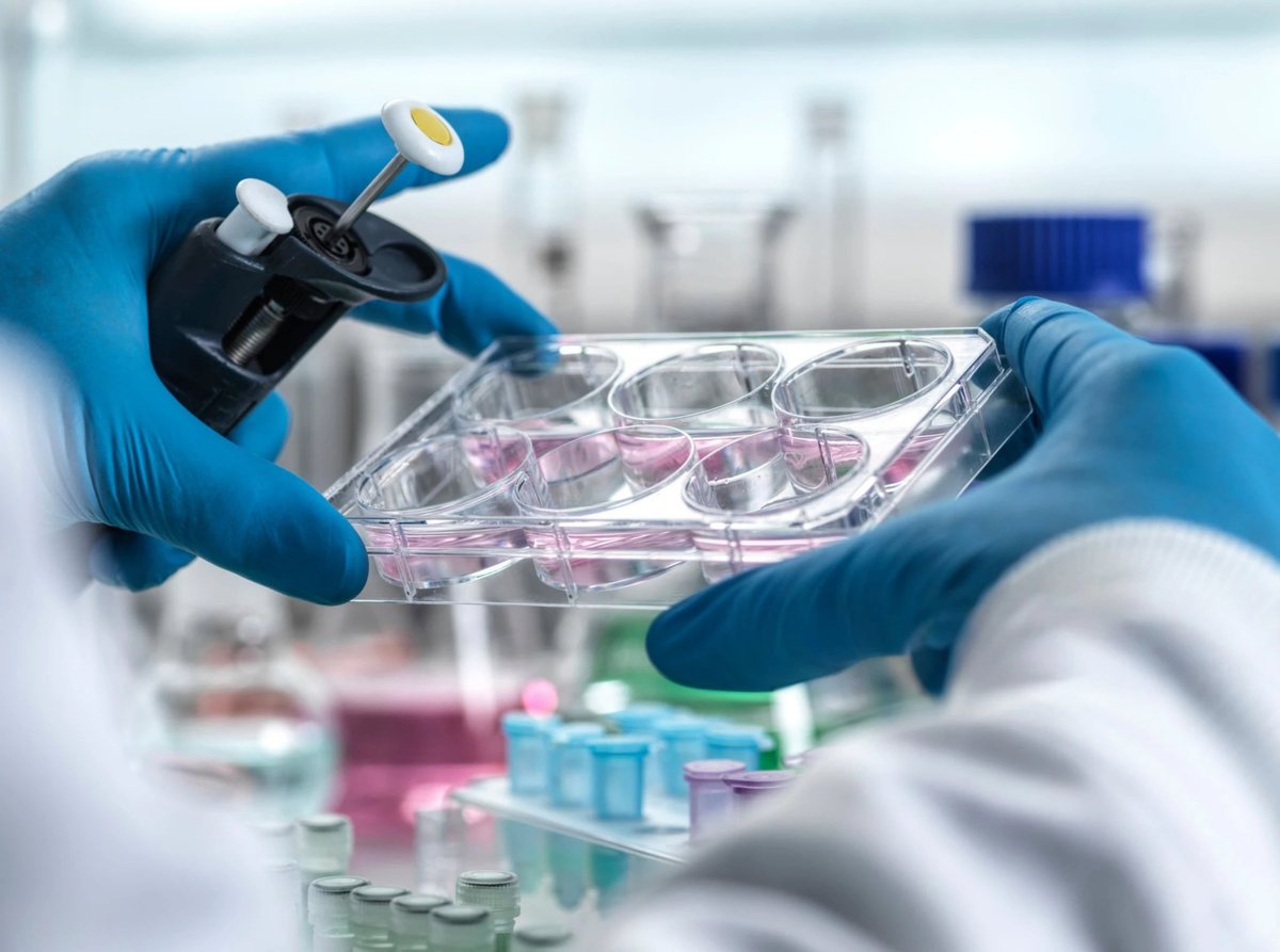 A lab technician wearing blue gloves